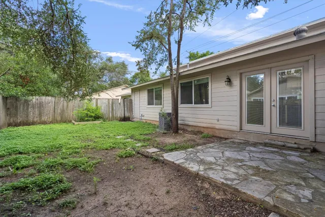a view of a house with yard and a large tree