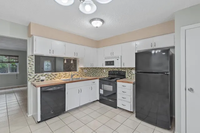 a kitchen with stainless steel appliances granite countertop a refrigerator sink and stove