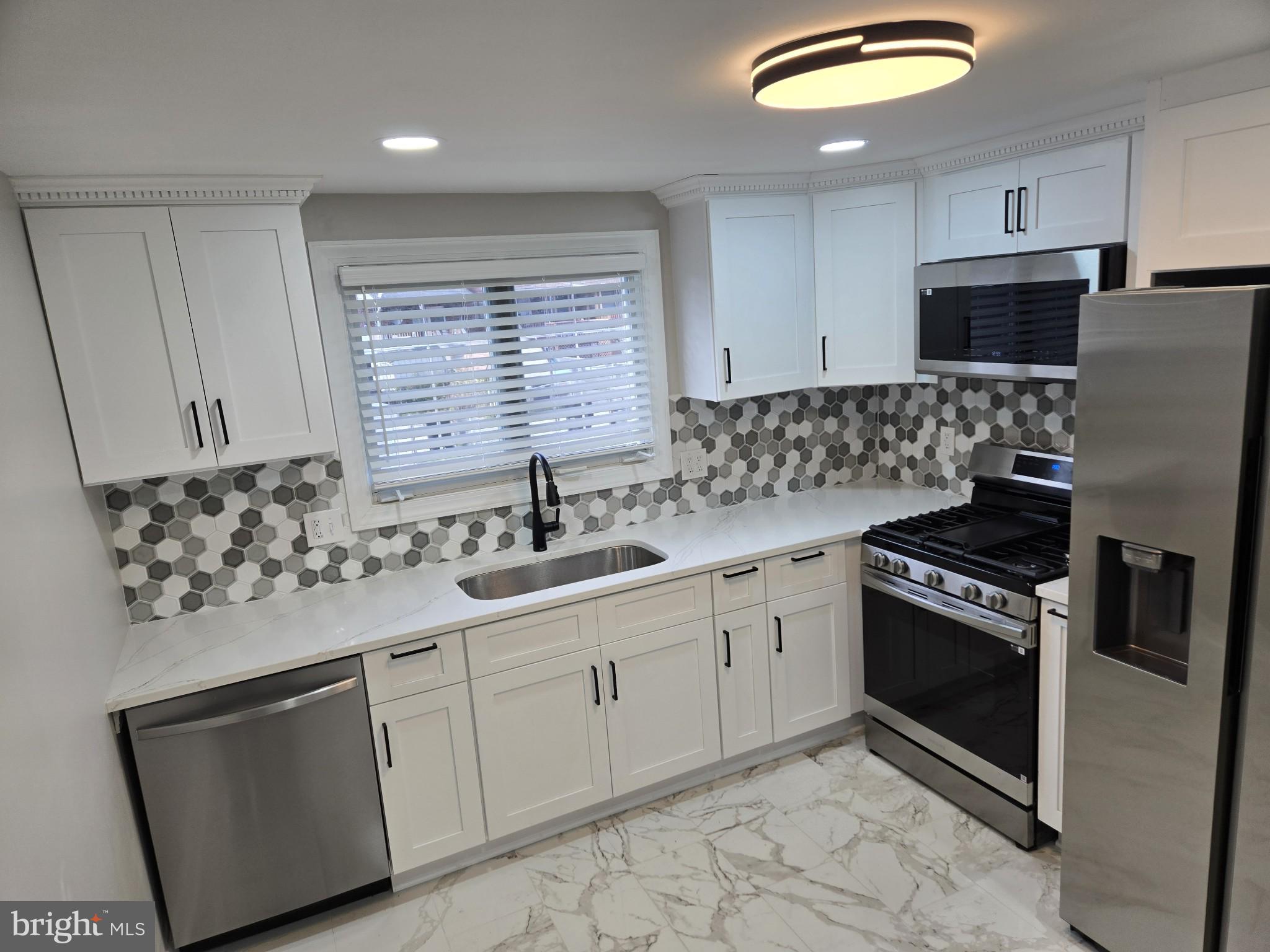 1016 Middleborough Road Essex, MD 21221 - Photo 9 of 33 a kitchen with stainless steel appliances granite countertop a sink stove and refrigerator