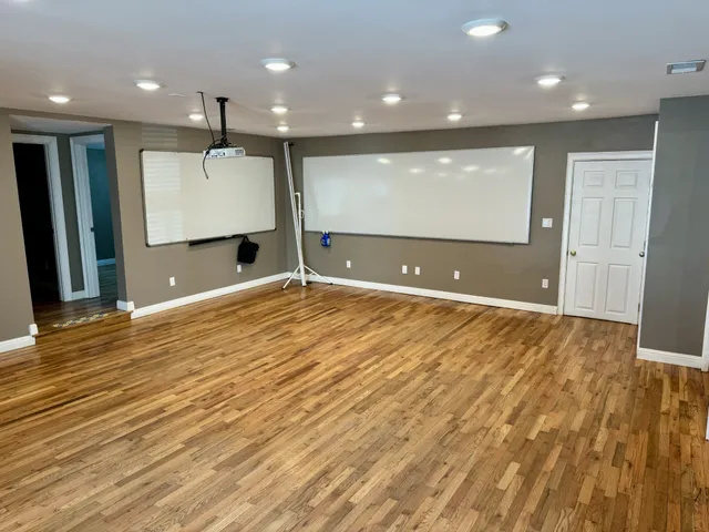 a view of a hallway with wooden floor and staircase