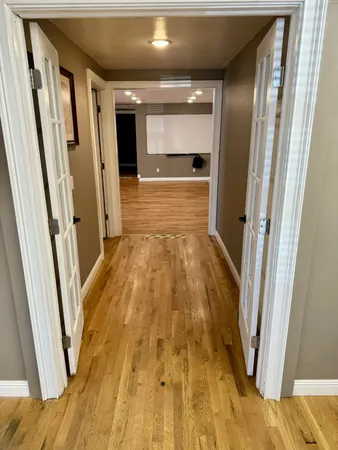 a view of an empty room with wooden floor and a window