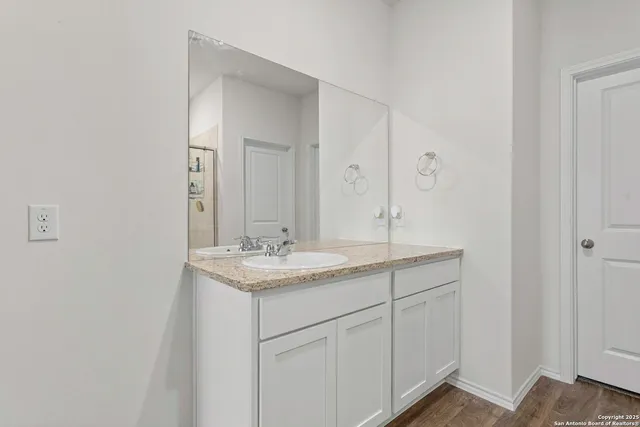 a bathroom with a granite countertop sink and a mirror