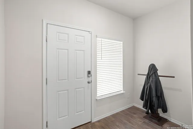 a view of a room with a window and a wooden floor