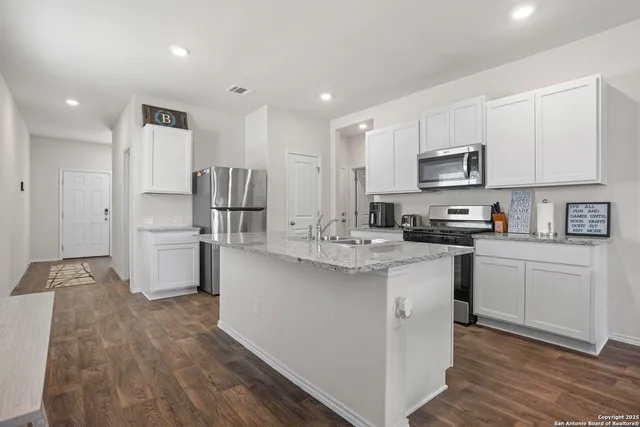 a kitchen with kitchen island white cabinets stainless steel appliances and sink