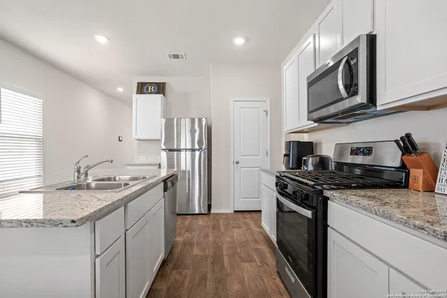 a kitchen with stainless steel appliances granite countertop a sink stove and refrigerator