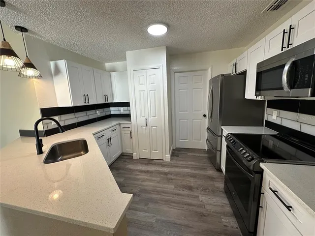a kitchen with stainless steel appliances a stove a microwave and a refrigerator