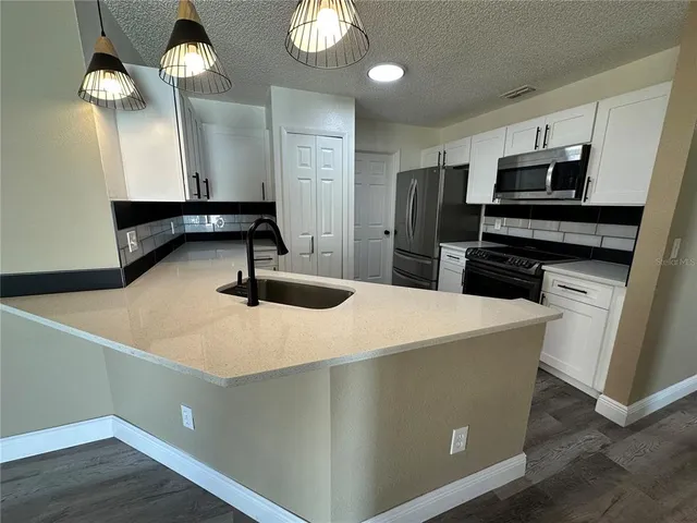 a kitchen with sink cabinets and stainless steel appliances