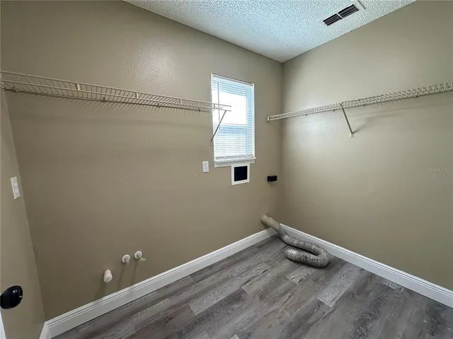 a view of a small space with wooden floor and windows
