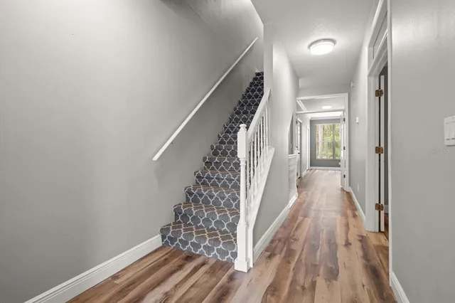 a view of a hallway with wooden floor and staircase
