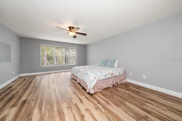 a bedroom with a bed and a chandelier fan
