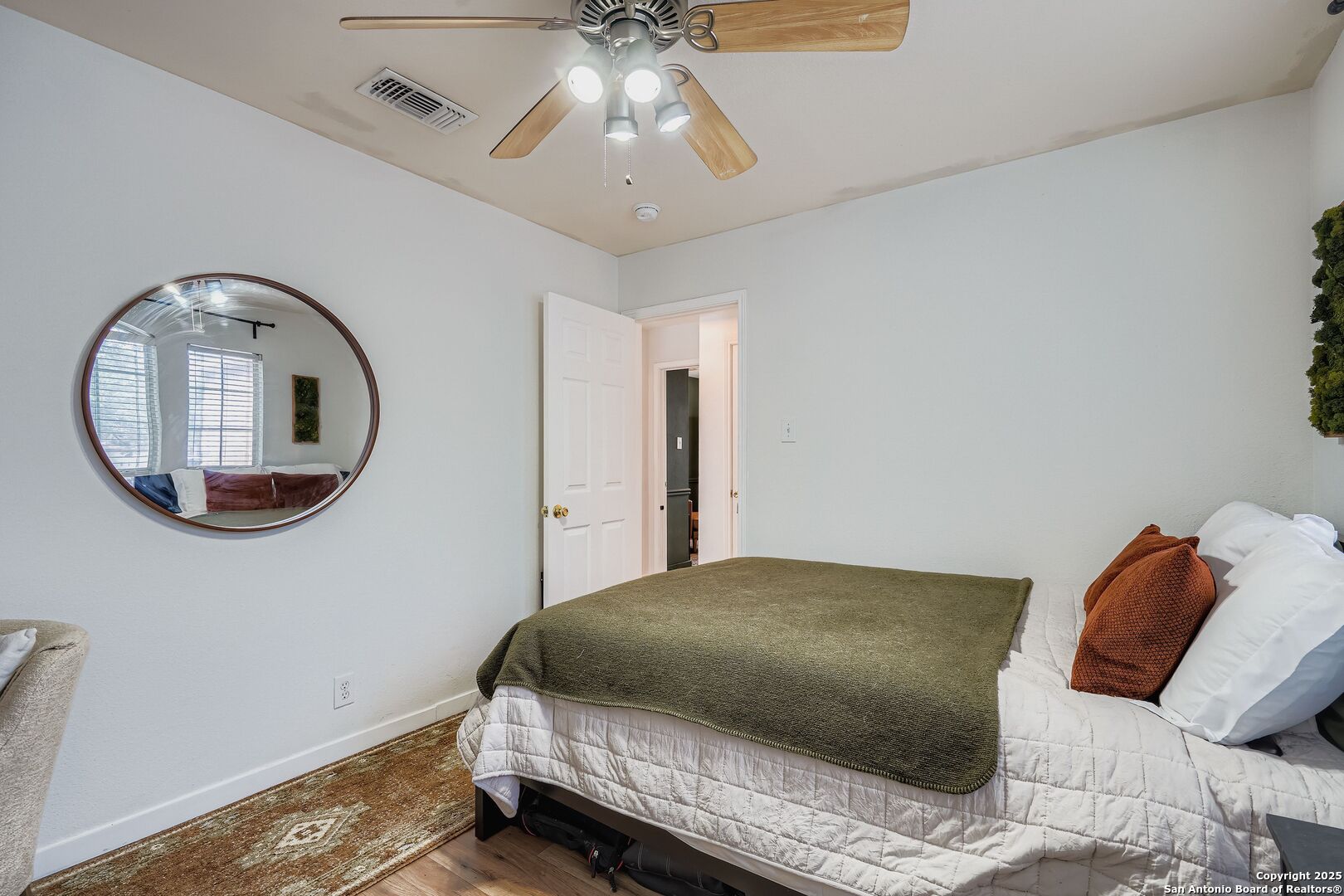15406 Spring Dew San Antonio, TX 78247 - Photo 20 of 26 a bedroom with a bed and a chandelier