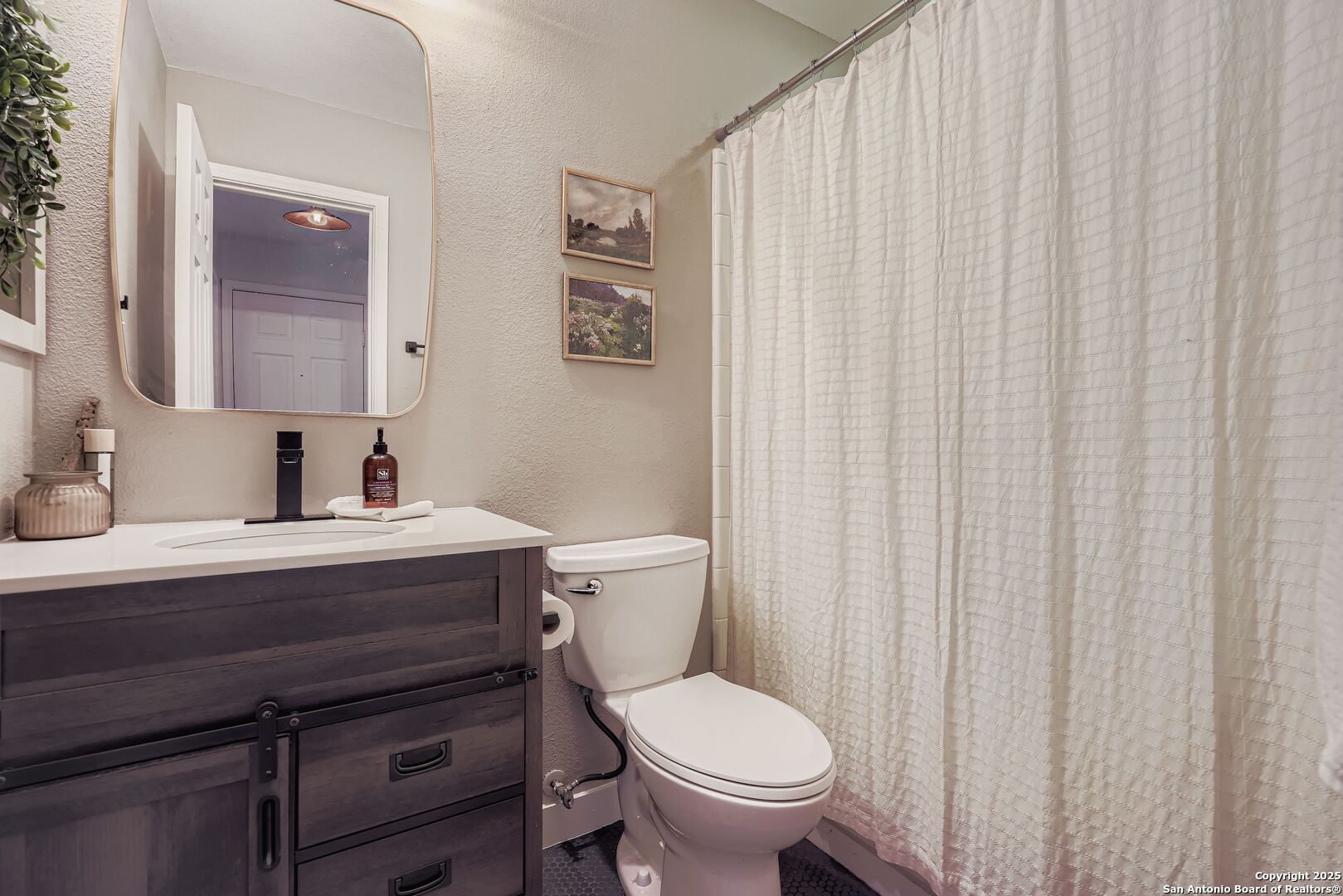 15406 Spring Dew San Antonio, TX 78247 - Photo 23 of 26 a bathroom with a toilet a sink and curtain