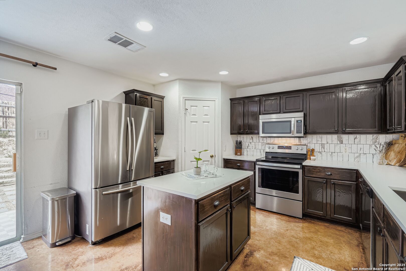 15406 Spring Dew San Antonio, TX 78247 - Photo 10 of 26 a kitchen with stainless steel appliances granite countertop a refrigerator stove microwave and sink