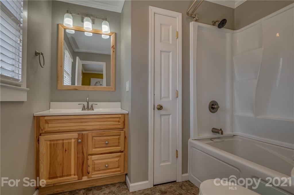 50 Owl Hollow Road Mill Spring, NC 28756 - Photo 30 of 45 a bathroom with a tub a sink and mirrors