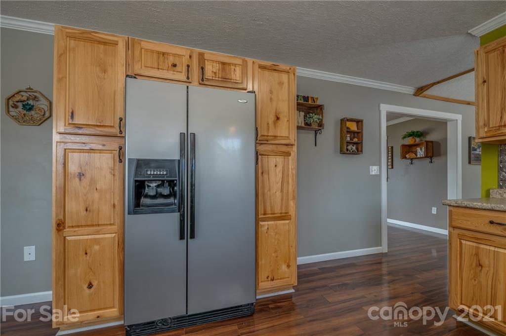 50 Owl Hollow Road Mill Spring, NC 28756 - Photo 31 of 45 a kitchen with stainless steel appliances a refrigerator and a wooden floor
