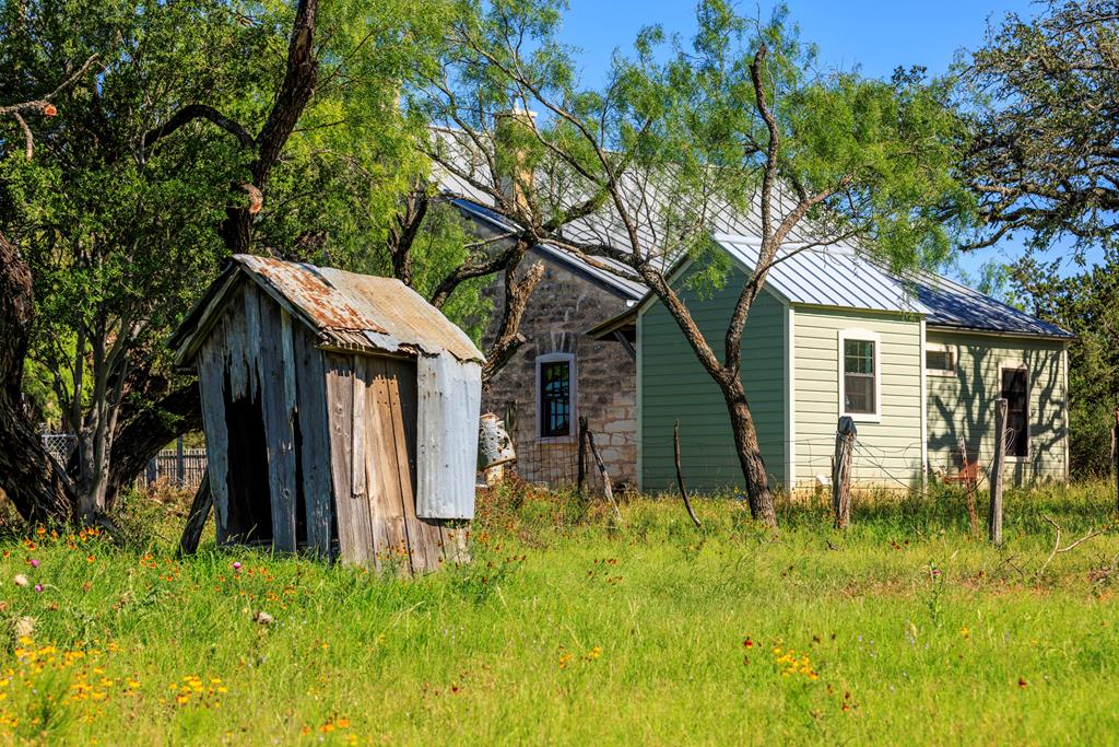 3610 Welgehausen Road Fredericksburg, TX 78624 - Photo 18 of 43 a backyard of a house with lawn chairs plants and tree