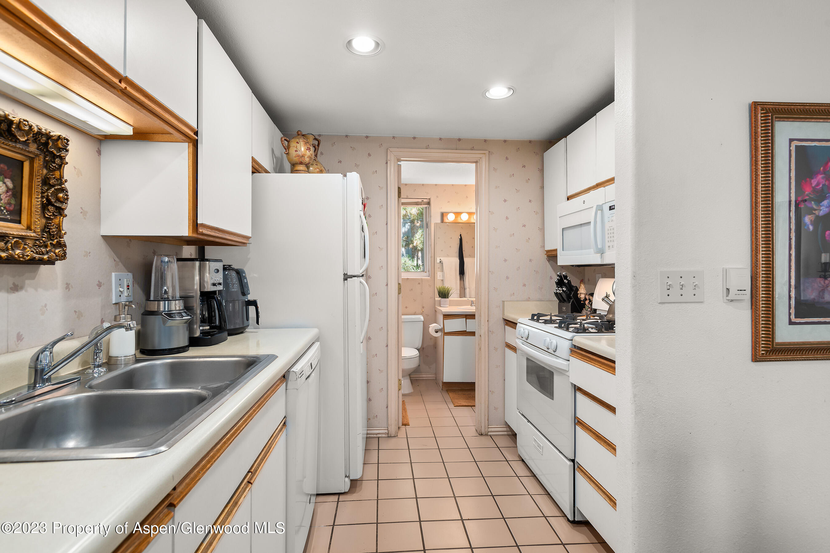 141-143 Swinging Bridge Lane Basalt, CO 81621 - Photo 23 of 35 a kitchen with white cabinets and appliances