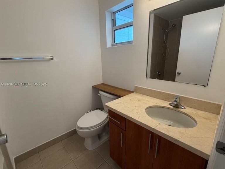 1712 Southwest 2nd Avenue, Unit 304 Miami, FL 33129 - Photo 12 of 18 a bathroom with a granite countertop sink a toilet and a mirror