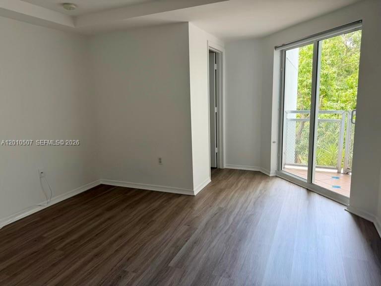 1712 Southwest 2nd Avenue, Unit 304 Miami, FL 33129 - Photo 15 of 18 a view of an empty room with wooden floor and a window