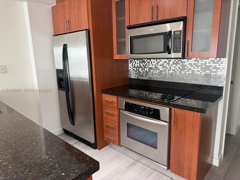 1712 Southwest 2nd Avenue, Unit 304 Miami, FL 33129 - Photo 3 of 18 a kitchen with granite countertop a stove and a refrigerator