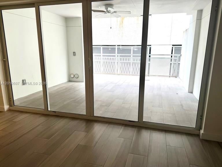 1712 Southwest 2nd Avenue, Unit 304 Miami, FL 33129 - Photo 4 of 18 an empty room with wooden floor and door