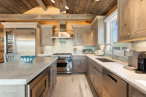 a kitchen with stainless steel appliances granite countertop a sink a stove and a refrigerator