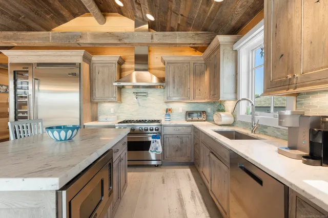 a kitchen with stainless steel appliances granite countertop a sink a stove and a refrigerator