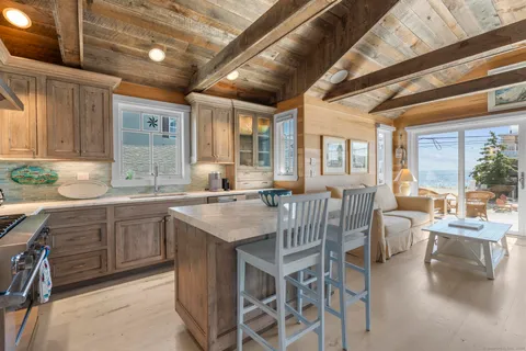 a dining hall with stainless steel appliances granite countertop a stove a sink dishwasher a dining table and chairs with wooden floor