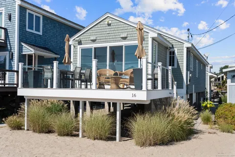 a view of a house with large windows and plants