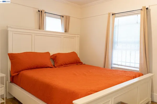 a blue bed sitting in a bedroom next to a window