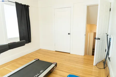 a view of a room with wooden floor and a bathroom