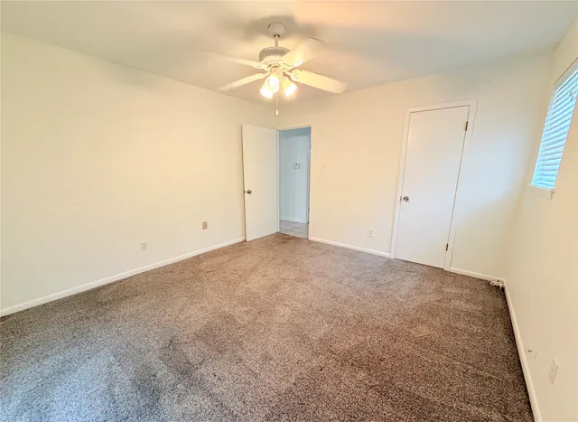 an empty room with a chandelier fan and a chandelier fan