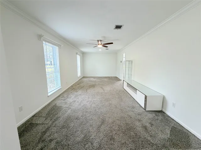 an empty room with a ceiling fan and windows