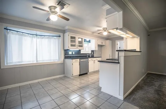 a kitchen with kitchen island granite countertop a stove a sink a window and a counter top space