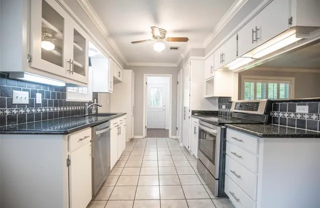 a kitchen with stainless steel appliances granite countertop a sink and cabinets