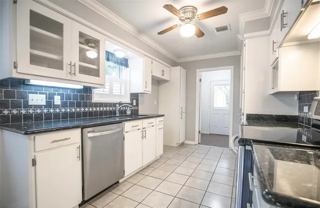 a kitchen with granite countertop a sink stainless steel appliances and cabinets