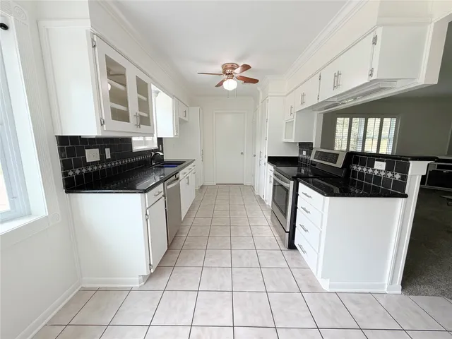 a kitchen with a sink a stove cabinets and a window
