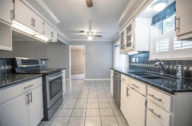 a kitchen with stainless steel appliances granite countertop a sink stove and cabinets