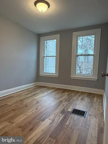 a view of a hallway with wooden floor and stairs