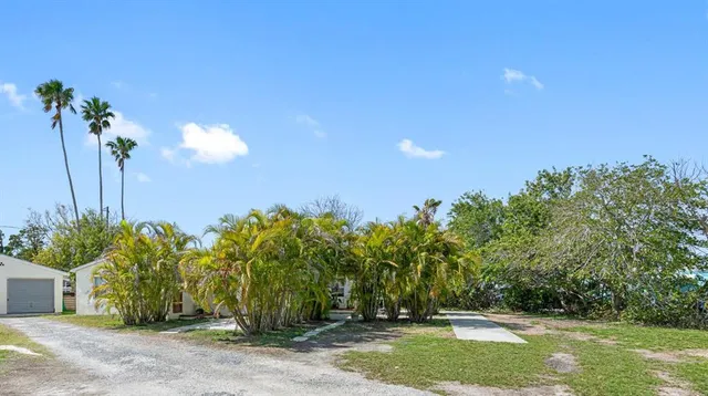 a view of a house with a yard and basketball court