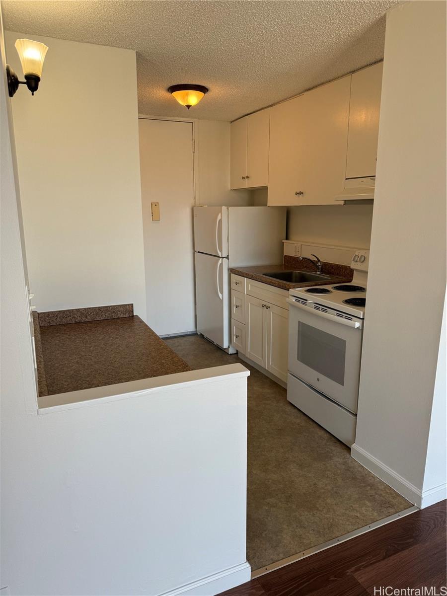 1112 Kinau Street, Unit 807 Honolulu, HI 96814 - Photo 4 of 10 a kitchen with a stove and a refrigerator