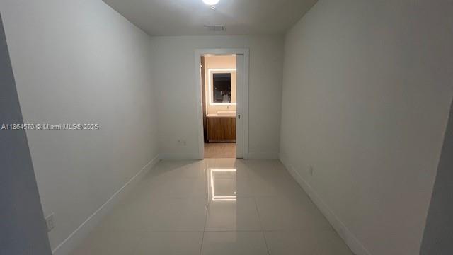 2960 Northeast 207th Street, Unit 607 Aventura, FL 33180 - Photo 4 of 11 a view of an empty room with wooden floor and a window