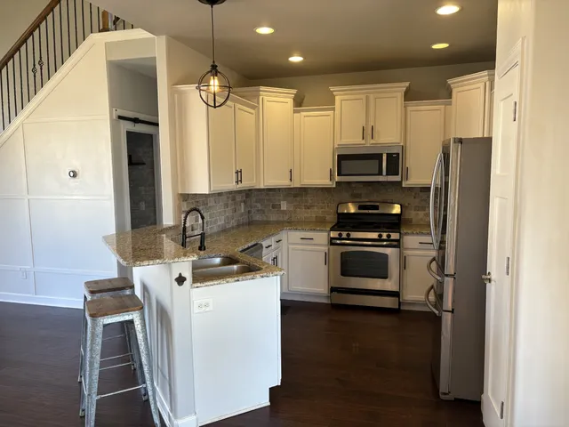 a kitchen with stainless steel appliances a stove refrigerator sink and microwave