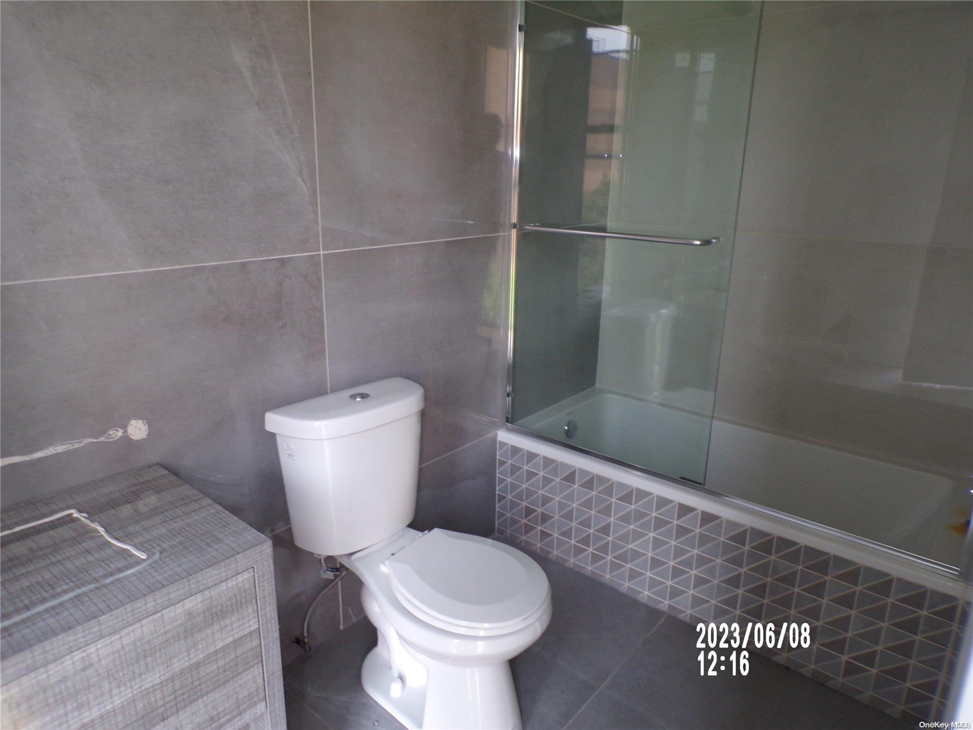 695 Monroe Street Brooklyn, NY 11221 - Photo 17 of 23 a white toilet sitting next to a bathroom sink and a shower