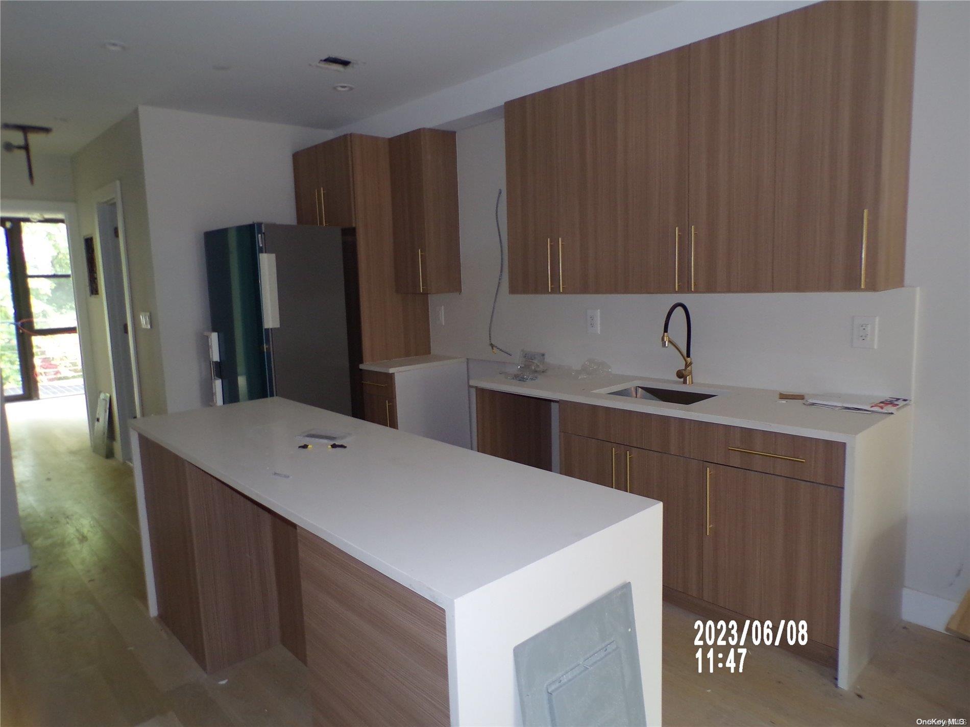 695 Monroe Street Brooklyn, NY 11221 - Photo 2 of 23 a kitchen with a sink a refrigerator and cabinets
