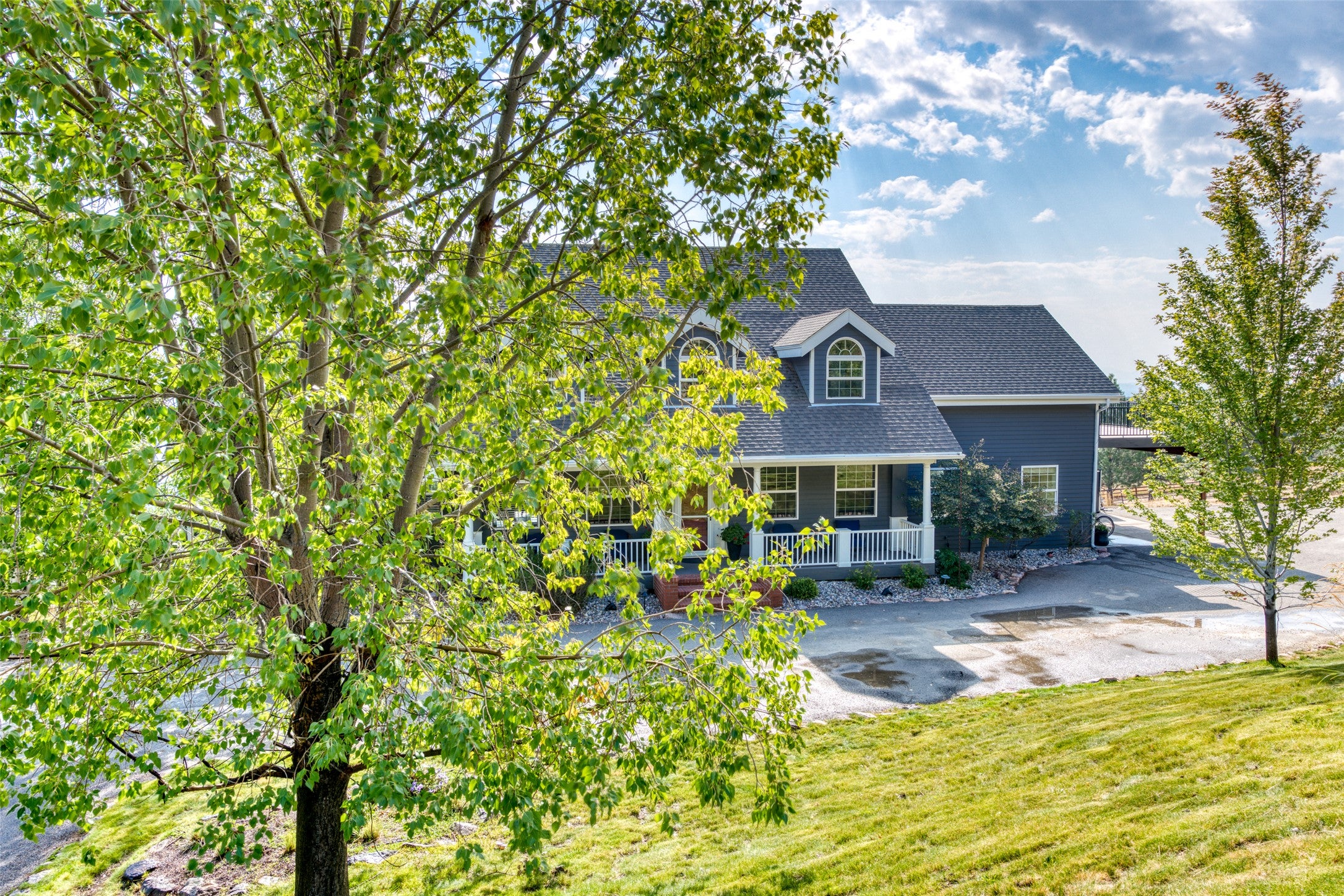 16374 Folsom Road Florence, MT 59833 - Photo 5 of 98 View of front of house featuring covered porch, a shingled roof, and a front yard