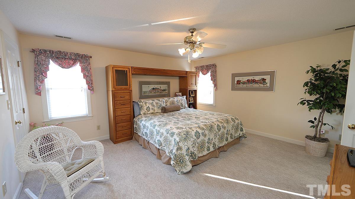 409 Guy Walker Way Durham, NC 27703 - Photo 20 of 47 a bedroom with a large bed and a chandelier