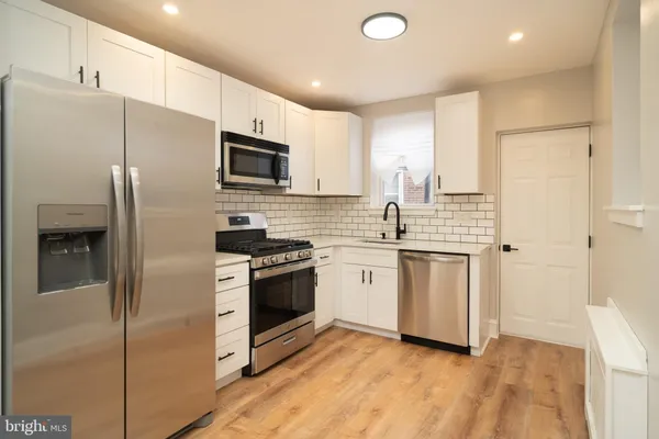 a kitchen with stainless steel appliances a refrigerator sink and microwave