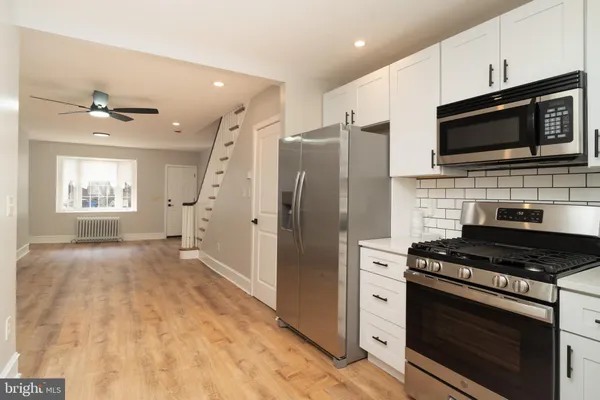 a kitchen with stainless steel appliances a stove a microwave and a refrigerator