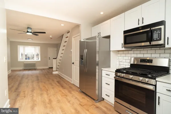 a kitchen with stainless steel appliances a stove a microwave and a refrigerator